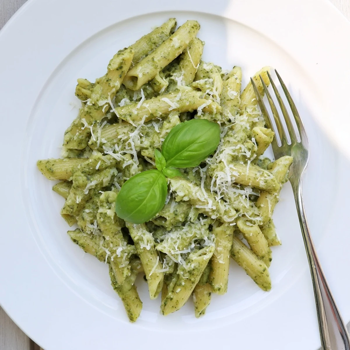 Creamy sunflower seed pesto pasta with a spoon, ready to serve, featuring golden toasted seeds and a bright, fresh basil aroma.