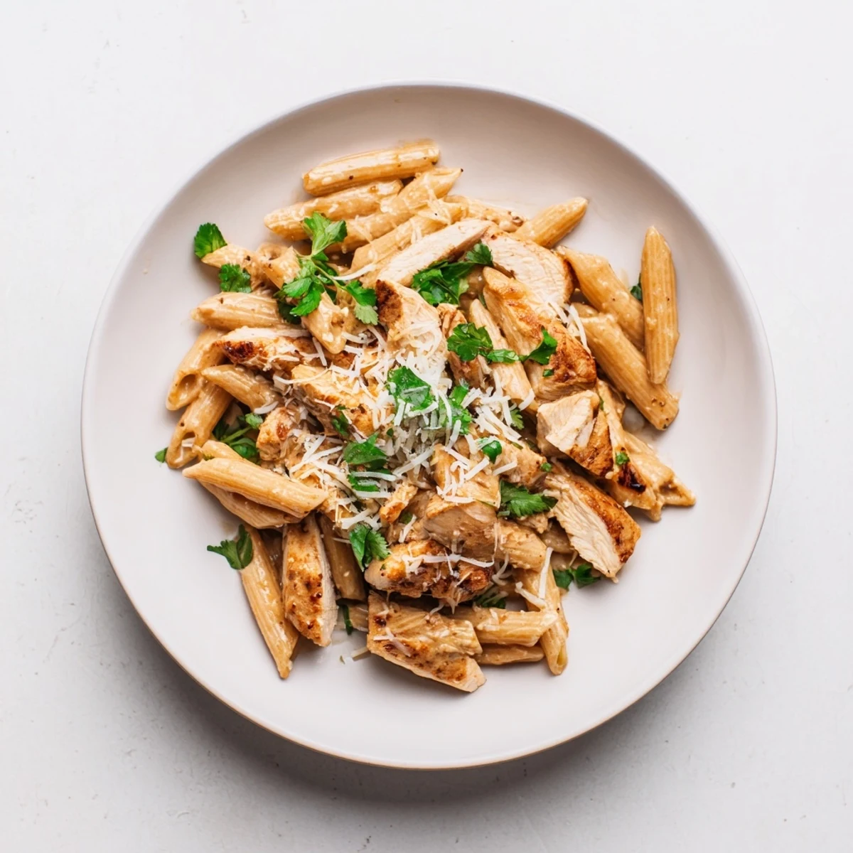 A close-up view of Honey Chipotle Chicken Pasta with tender penne noodles, savory chicken pieces, and a drizzle of honey-lime sauce.