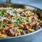 Savory Comforting Ground Beef Orzo Dinner served in a warm bowl, garnished with fresh parsley and cheese.