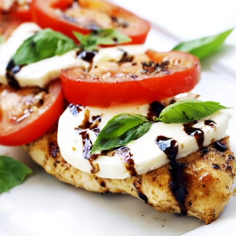 Caprese Chicken Skillet with bubbling mozzarella and ripe tomatoes, drizzled with balsamic glaze in a hot skillet.