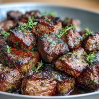 Juicy garlic herb steak bites sizzle in a cast iron skillet for a flavorful one-pan dinner.