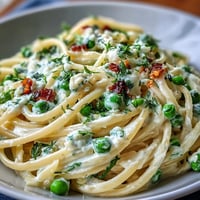 Creamy ricotta and lemon linguine with sweet peas, bright citrus zest, and Parmesan for a fresh spring pasta dinner.  